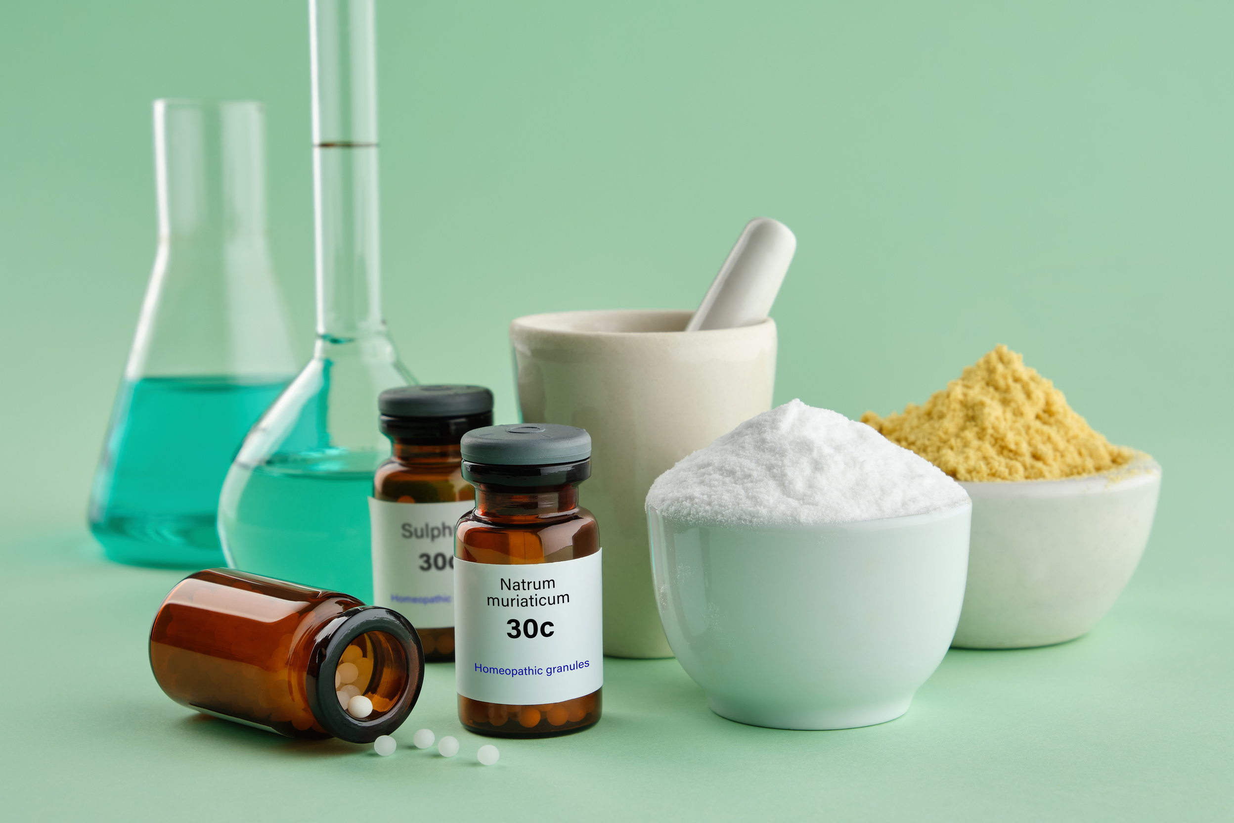 Bottles of homeopathic drugs - Natrum muriaticum, Sulphur, substances and ingredients for preparation of homeopathic remedies. Homeopathy medicine.