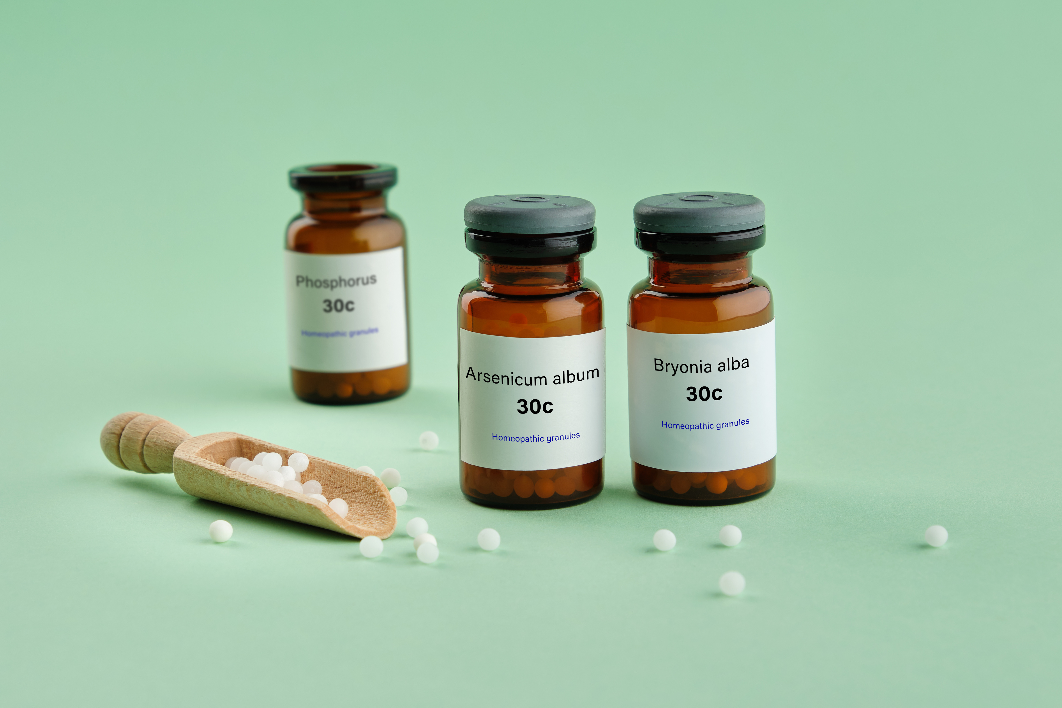 Bottles of homeopathic globules - Arsenicum album, Bryonia alba, Phosphorus - homeopathic remedies for treatment and prophylaxis of Coronavirus Covid-19. Homeopathic bottles on green background.